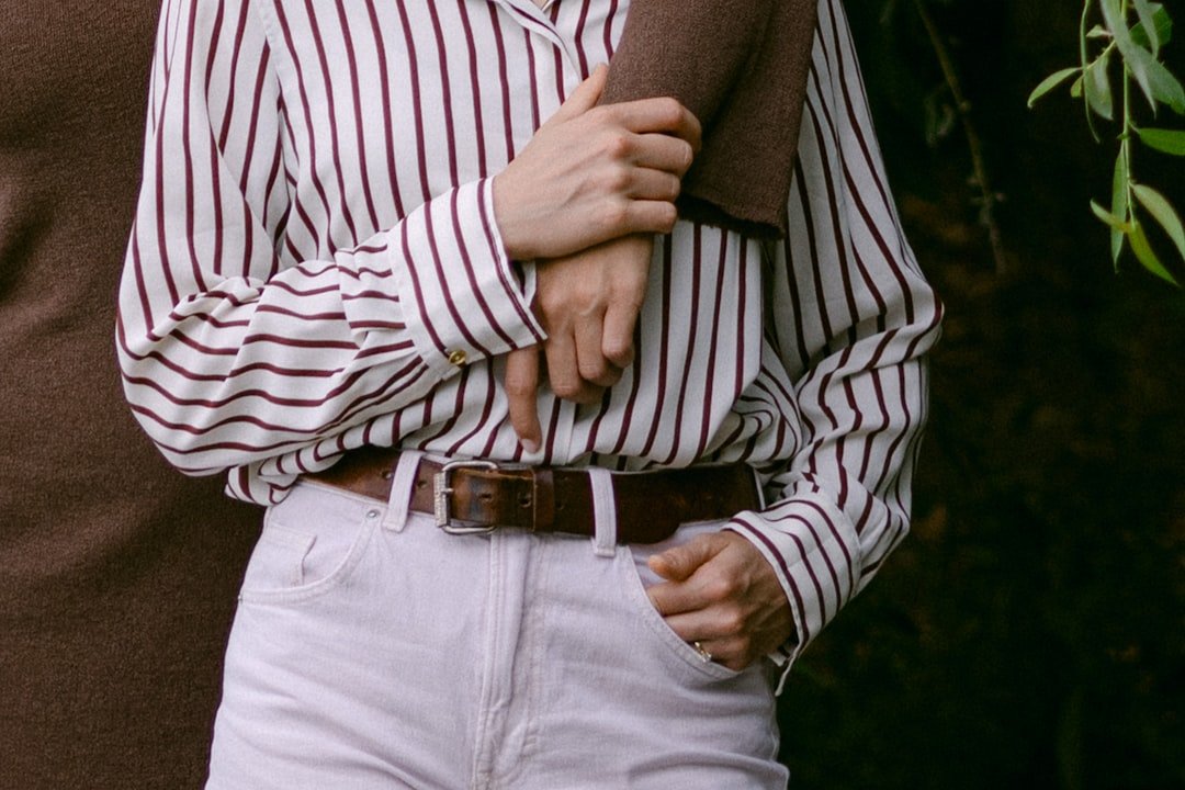 Couple holding hands with striped shirt and white jeans