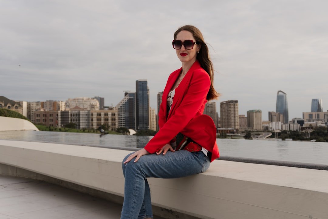 Woman in red blazer sitting with city skyline background